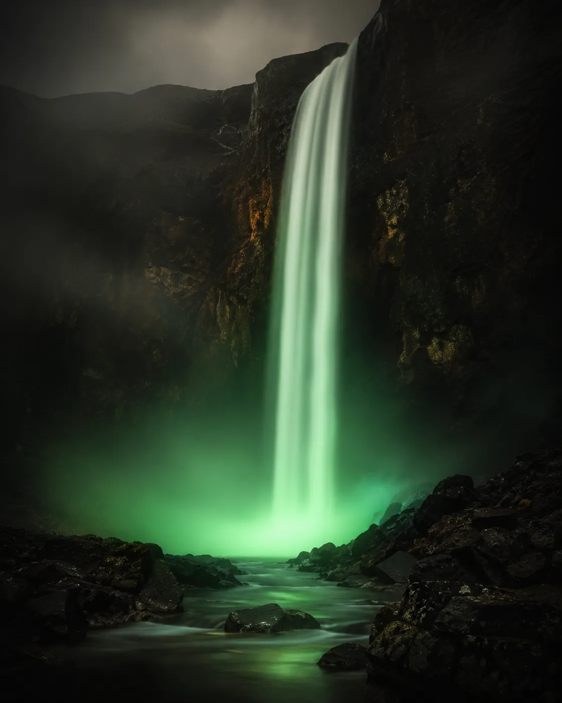 A waterfall glowing emerald from below.
